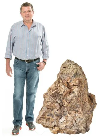 Raimund Loacker, Steinmetzmeister, neben einem Rohblock aus Naturstein