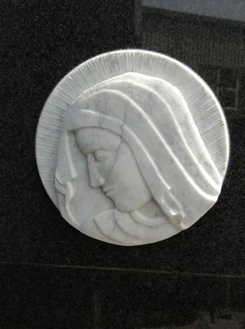 Rundes Marmorrelief mit dem Bildnis einer Madonna auf dunklem Stein